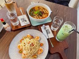 Fresh pasta and curry dishes on wooden table
